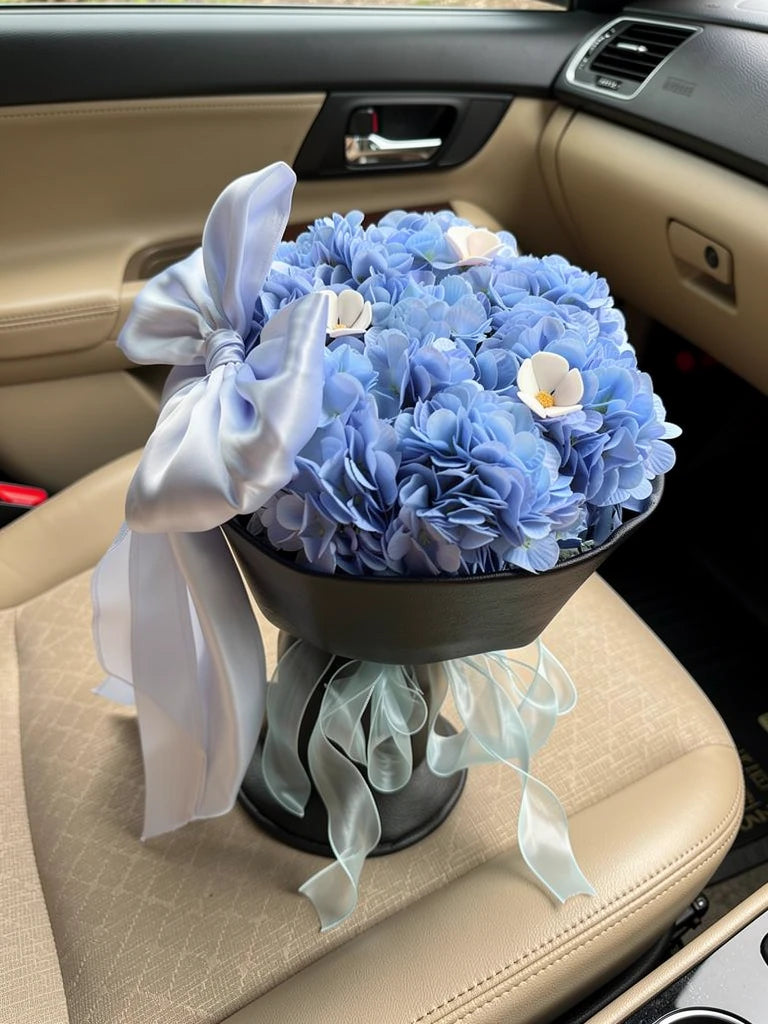 Blue Moon Hydrangea Bow Bouquet, Medium, high-angle car-seat view; AI lifestyle illustration