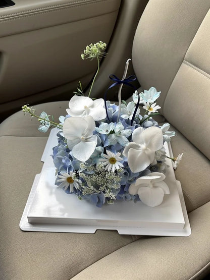 Blue Orchid Dream Flower Cake, Medium, high-angle car-seat view; AI lifestyle illustration