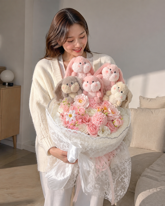 Woman holding the large Bunny Love Bouquet with five plush bunnies and pink and ivory flowers