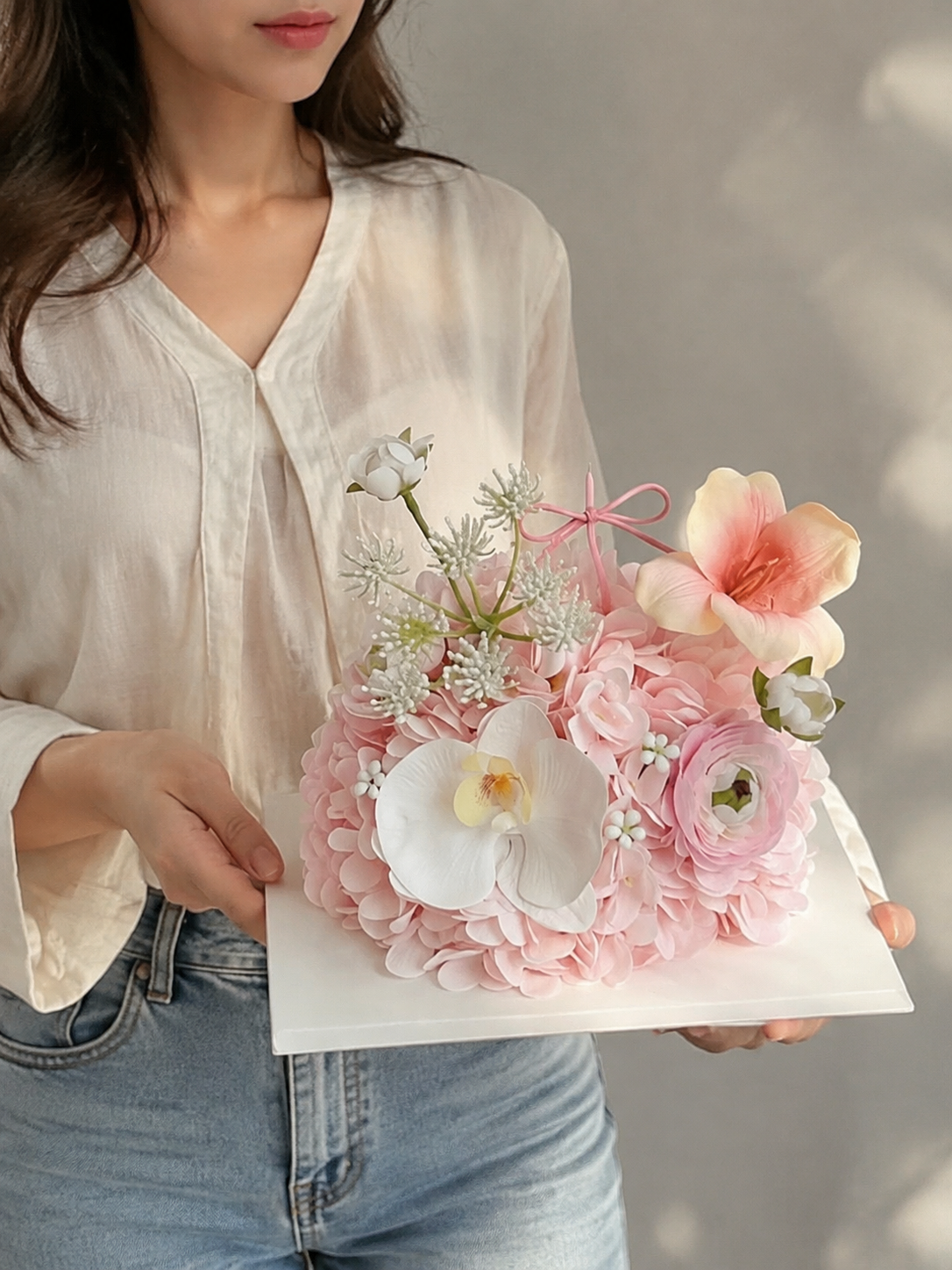 Petal Party Flower Cake – Blush Pink decorative flower cake, not edible – AI-assisted model-held angled view