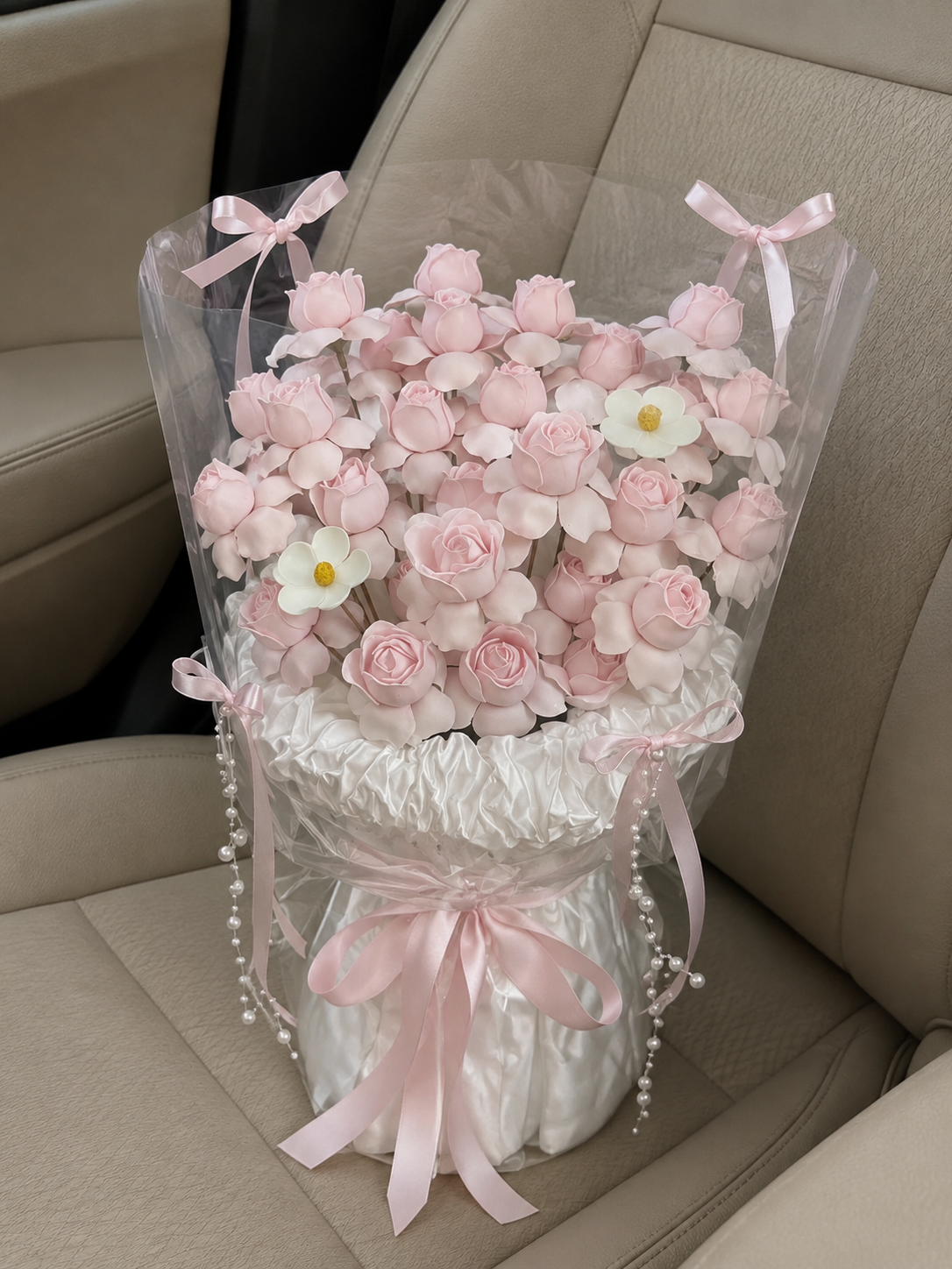 Pink Blossom Daisy Ribbon Frame Bouquet – high-angle bouquet on parked car seat