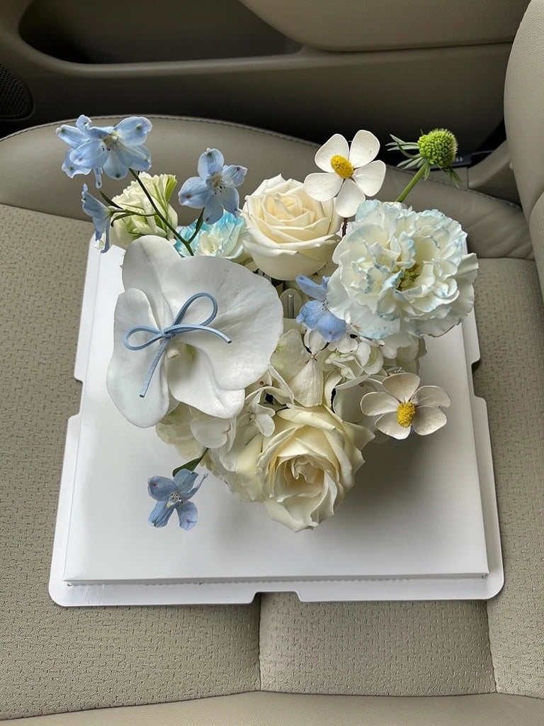 Ivory Blue Blossom Flower Cake, Medium, high-angle car-seat view; AI lifestyle illustration