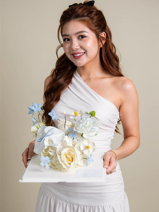 Nguyen Lan holding Ivory Blue Blossom Flower Cake, Medium; AI lifestyle illustration
