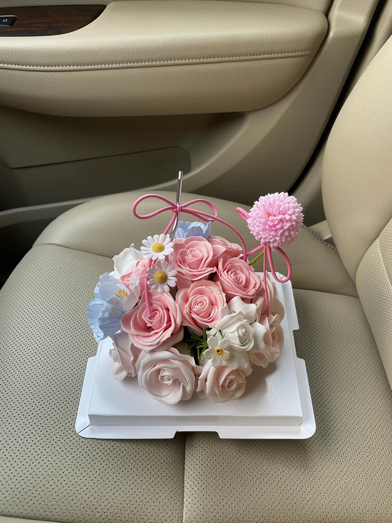 Petite Rose Celebration Flower Cake, Medium, high-angle car-seat view; AI lifestyle illustration