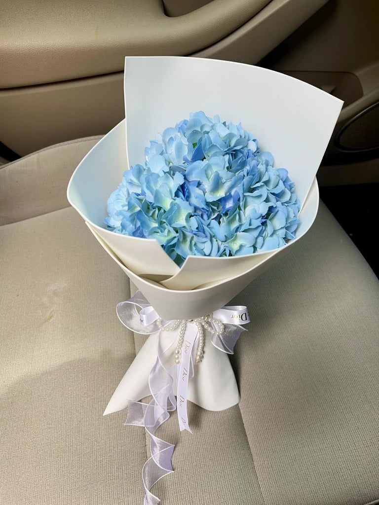 Sky Blue Hydrangea Small Bouquet, Small, high-angle car-seat view; AI lifestyle illustration